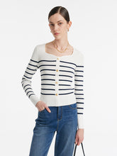 A lady wears a striped knit top.